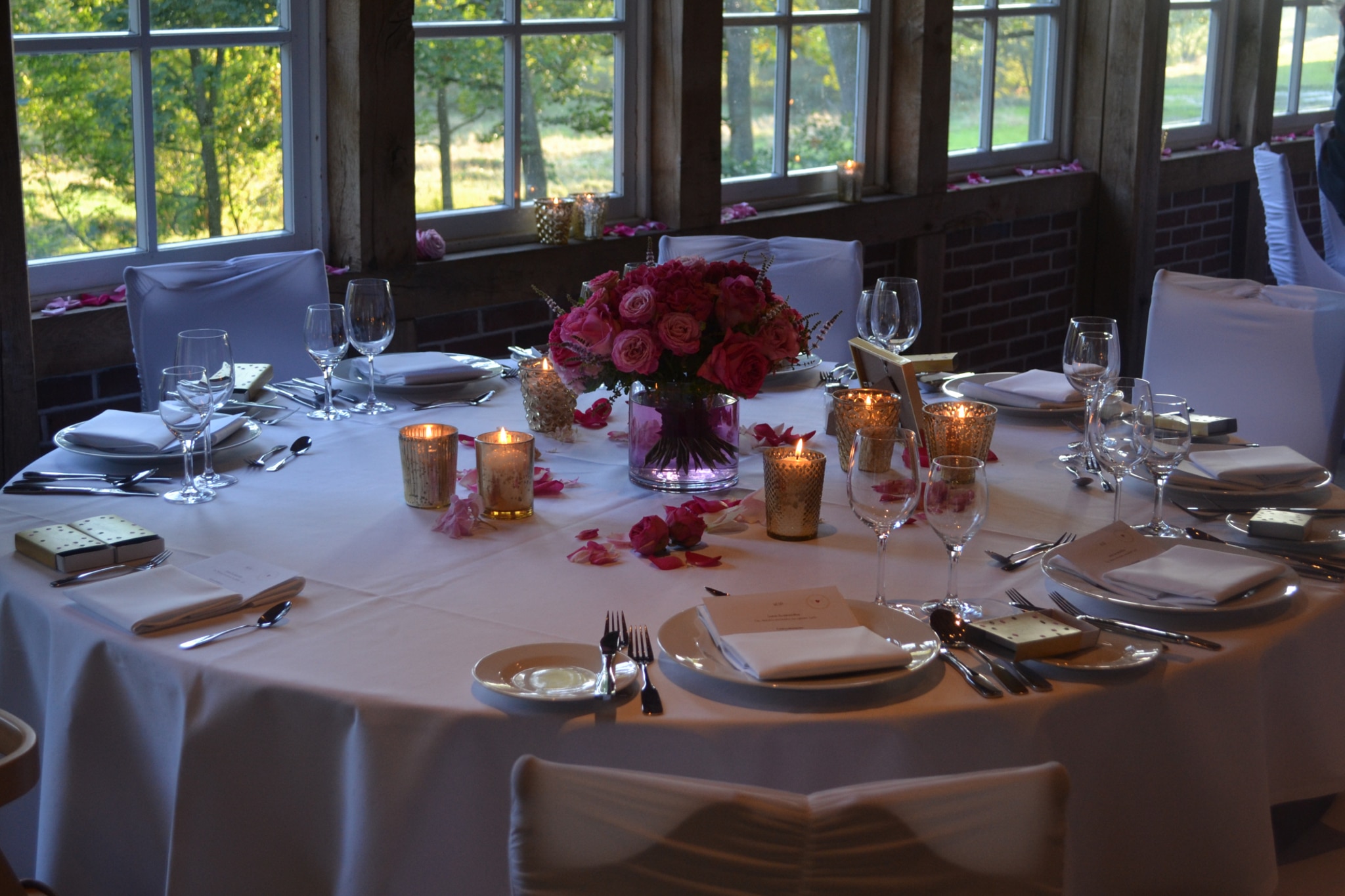 Hochzeit feiern im Landhaus Haverbeckhof: Tischdekoration mit pinkfarbenen Rosen und Kerzen